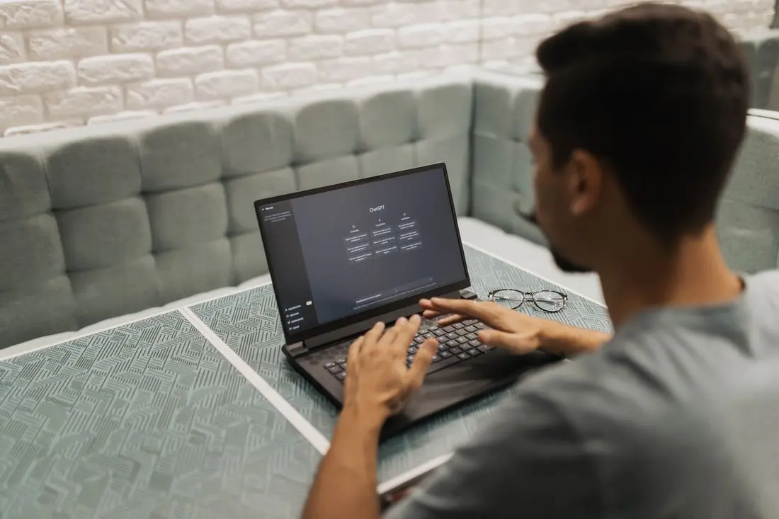 A man working on a laptop in a cozy, modern office space with a focus on technology