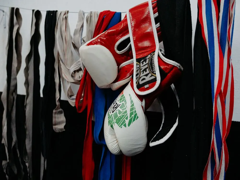Boxing gloves hanging on a rack in a gym