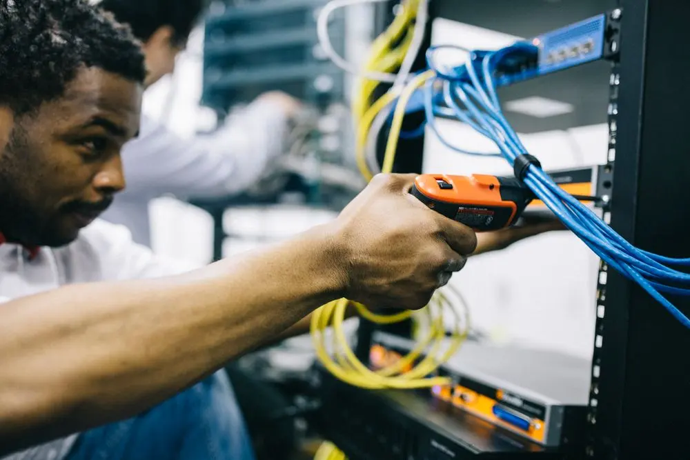 Technician working on network hardware in a data centre